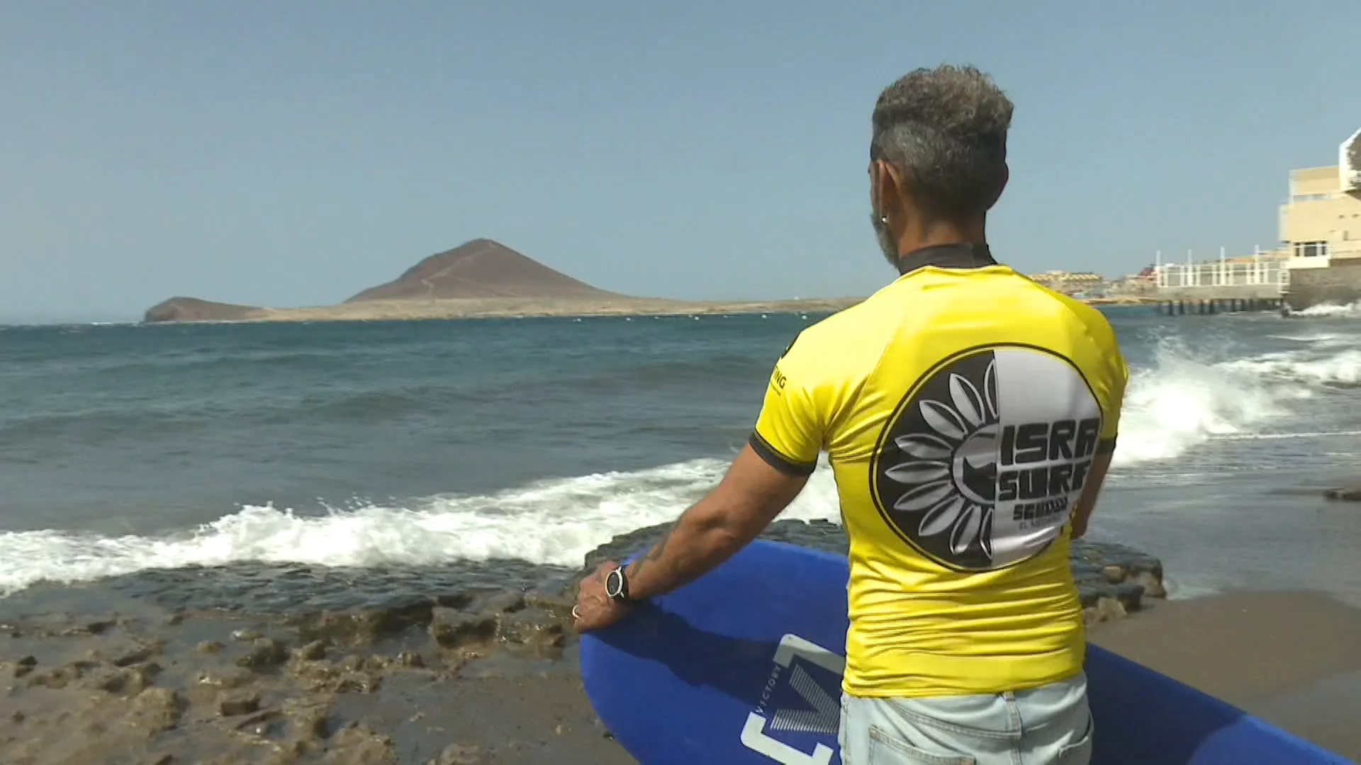 Un surfista mira las olas antes de entrar en el agua