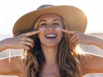 Una mujer con crema solar en el rostro