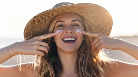 Una mujer con crema solar en el rostro Una mujer con crema solar en el rostro