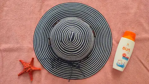 Crema solar y sombrero como medida física de protección contra las quemaduras del sol Crema solar y sombrero como medida física de protección contra las quemaduras del sol