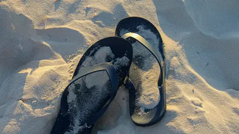 Chanclas de dedo en la arena Chanclas de dedo en la arena