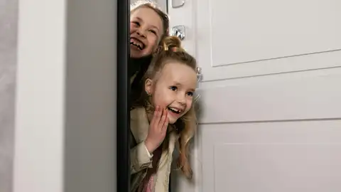 Dos hermanas abren la puerta de la habitación Dos hermanas abren la puerta de la habitación