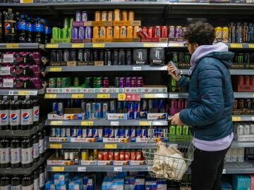 Un joven mira la sección de bebidas energéticas en el supermercado