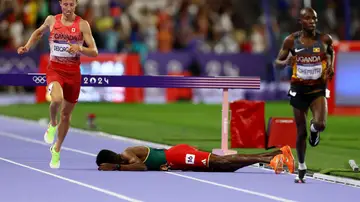 Lamecha Girma de Etiopía yace herido tras tropezar con un obstáculo durante la final de la carrera de obstáculos Lamecha Girma de Etiopía yace herido tras tropezar con un obstáculo durante la final de la carrera de obstáculos