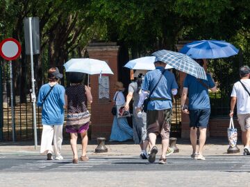 Personas con sombrillas en Sevilla