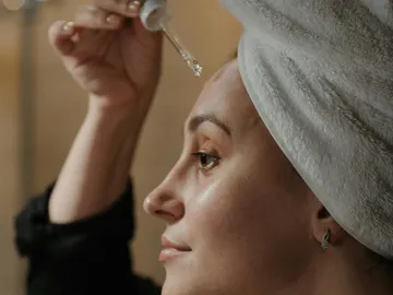 Mujer aplicándose un aceite Mujer aplicándose un aceite