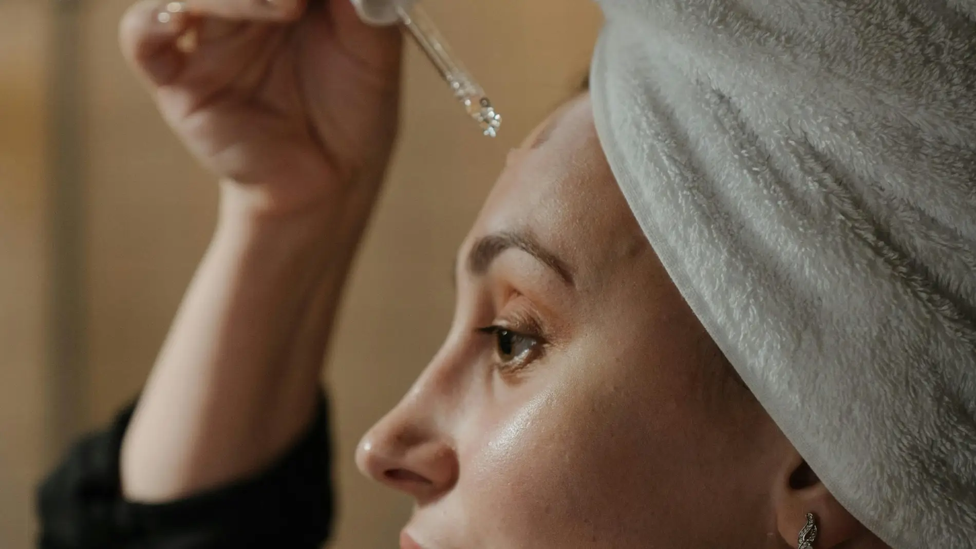 Mujer aplicándose un aceite Mujer aplicándose un aceite