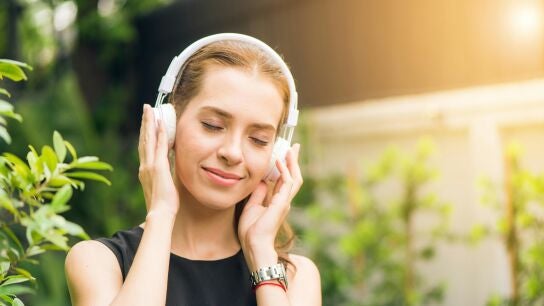 Una mujer escucha m&uacute;sica a trav&eacute;s de los auriculares