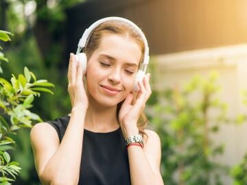 Una mujer escucha música a través de los auriculares