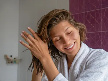 Una mujer cuidándose el pelo Una mujer cuidándose el pelo