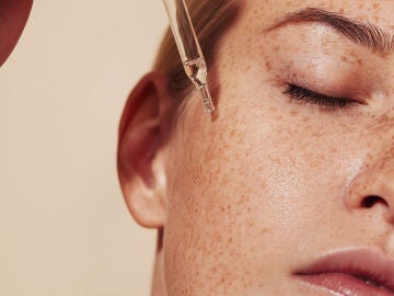 Mujer bronceada aplicándose retinol