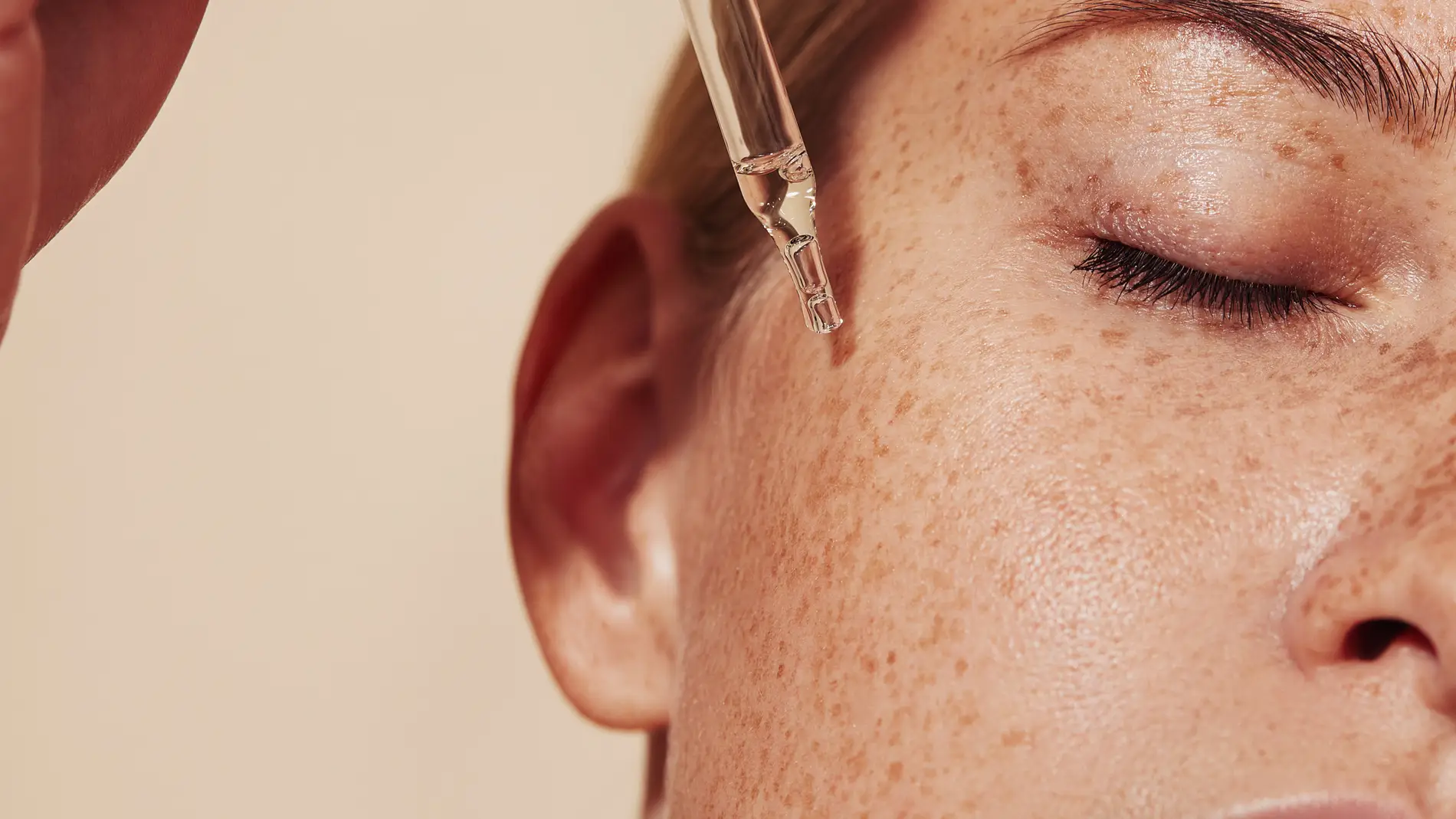 Mujer bronceada aplicándose retinol Mujer bronceada aplicándose retinol