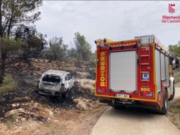 Un equipo de bomberos junto al vehículo que ha provocado el incendio en Castellón