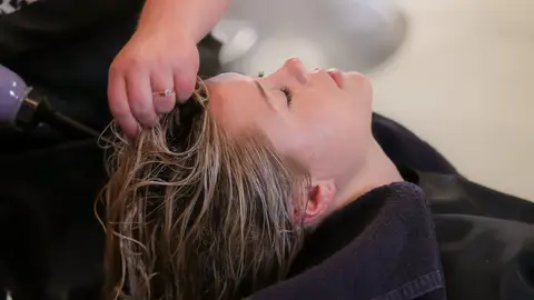 Peluquera lavando el pelo a una clienta Peluquera lavando el pelo a una clienta