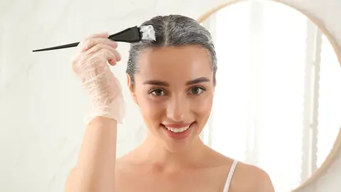 Mujer tiñéndose el pelo Mujer tiñéndose el pelo