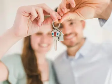 Una pareja muestra las llaves de su nuevo hogar Una pareja muestra las llaves de su nuevo hogar