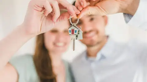 Una pareja muestra las llaves de su nuevo hogar Una pareja muestra las llaves de su nuevo hogar