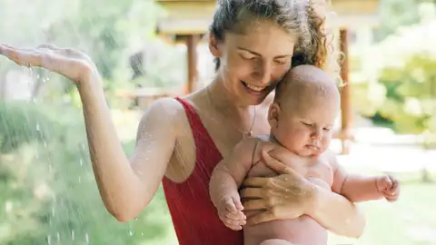 Madre e hijo refrescándose para evitar el calor Madre e hijo refrescándose para evitar el calor