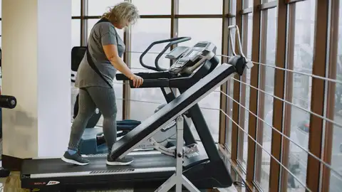 Mujer entrenando en la cinta de caminar Mujer entrenando en la cinta de caminar