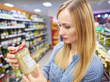 Mujer mirando la etiqueta de un bote de cristal