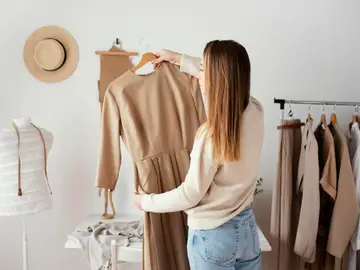 Mujer eligiendo prendas para su armario cápsula Mujer eligiendo prendas para su armario cápsula