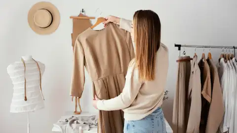 Mujer eligiendo prendas para su armario cápsula Mujer eligiendo prendas para su armario cápsula