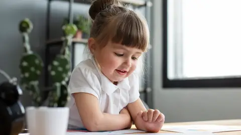 Niña mirando sus dibujos Niña mirando sus dibujos