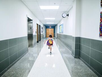 Niña corriendo por el pasillo de un colegio