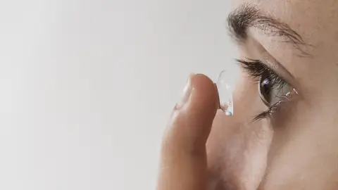 Una mujer poniéndose las lentillas Una mujer poniéndose las lentillas