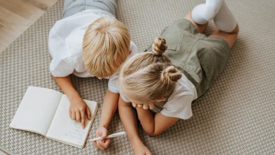 Ni&ntilde;os con una libreta