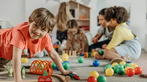 Un niño en el colegio juega con sus compañeros Un niño en el colegio juega con sus compañeros