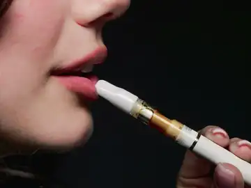 Imagen de archivo de una mujer fumando vaper. Imagen de archivo de una mujer fumando vaper.