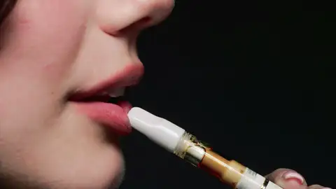 Imagen de archivo de una mujer fumando vaper. Imagen de archivo de una mujer fumando vaper.