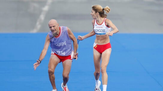 Elena Congost ayuda a su gu&iacute;a Mia Carol en el marat&oacute;n