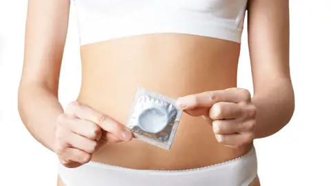Mujer sujetando un preservativo Mujer sujetando un preservativo