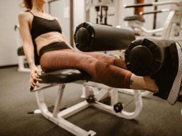 Una mujer entrenando fuerza en una máquina