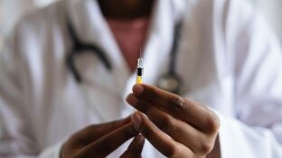 Un m&eacute;dico preparando una vacuna