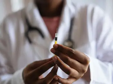 Un médico preparando una vacuna Un médico preparando una vacuna