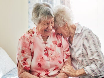 Dos mujeres mayores charlando y sonriendo