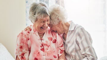 Dos mujeres mayores charlando y sonriendo