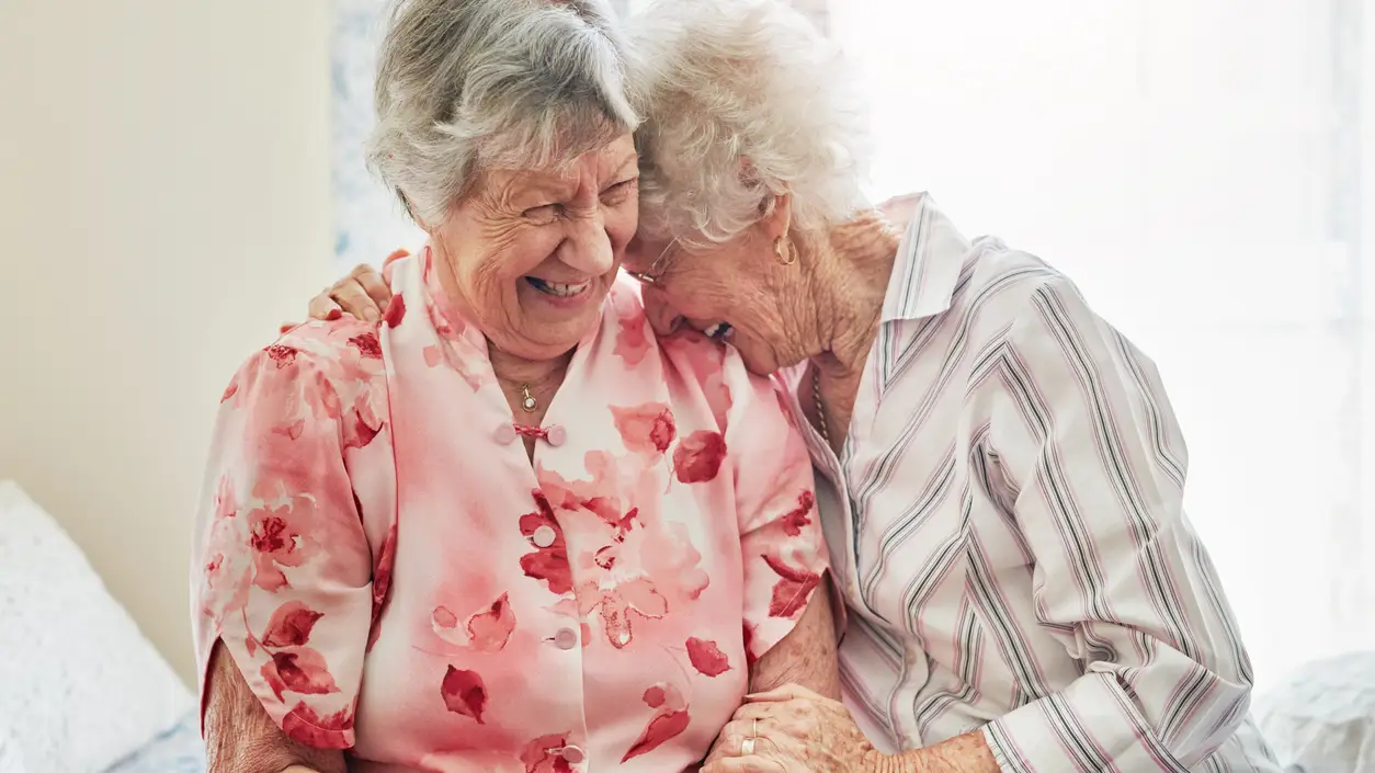 Dos mujeres mayores charlando y sonriendo