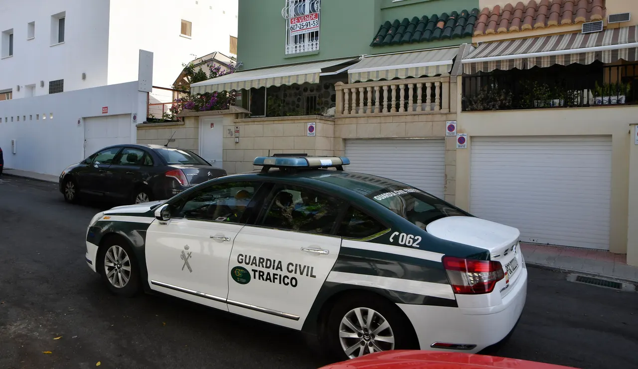 Un coche de la Guardia Civil junto al domicilio en la barriada de Aguadulce, Roquetas de Mar (Almería)