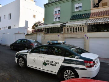 Un coche de la Guardia Civil junto al domicilio en la barriada de Aguadulce, Roquetas de Mar (Almería)