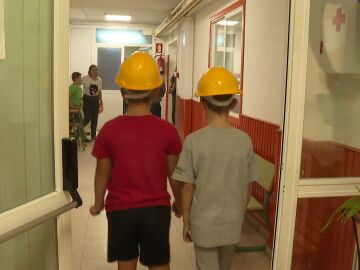 Niños con casco de obra en el colegio