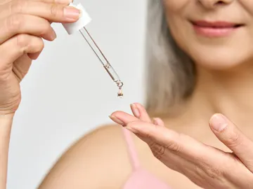 Mujer echándose aceite Mujer echándose aceite