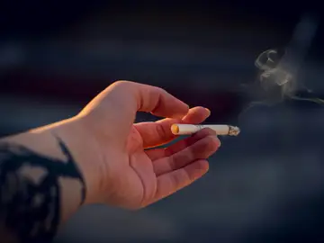 Una mano con un cigarro Una mano con un cigarro