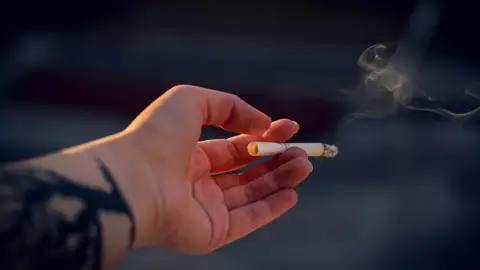 Una mano con un cigarro Una mano con un cigarro