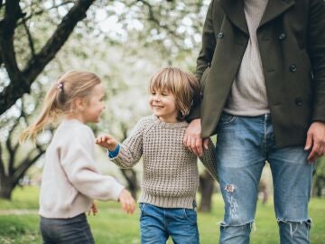 Un padre con sus dos hijos en un parque