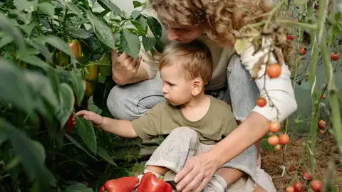 Una madre le enseña a su hijos el huerto Una madre le enseña a su hijos el huerto
