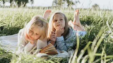 Niñas leyendo en la naturaleza Niñas leyendo en la naturaleza